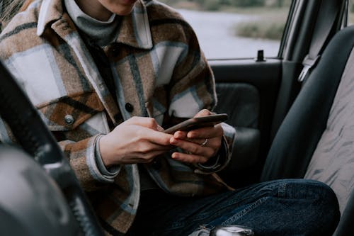 Free Person Sitting in the Car Using Cellphone Stock Photo