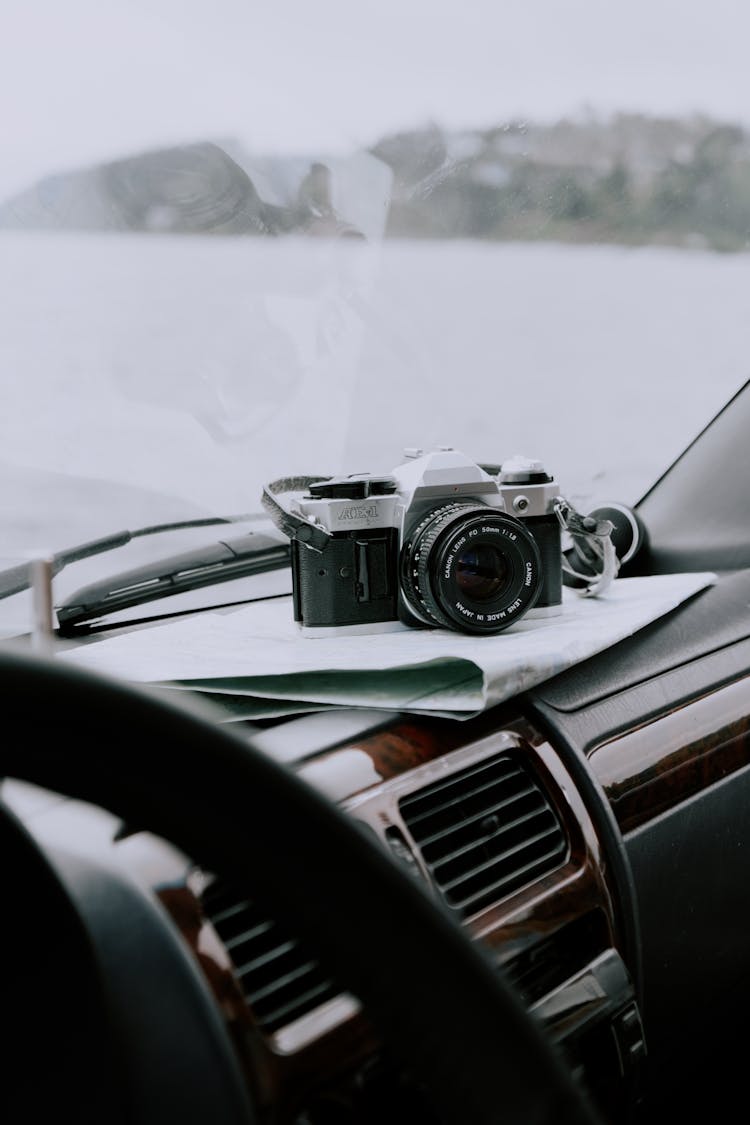 Black And Silver Dslr Camera On Car Dashboard