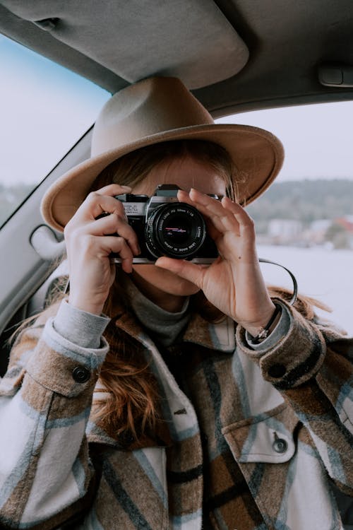 Woman in Brown Hat Holding Black Camera