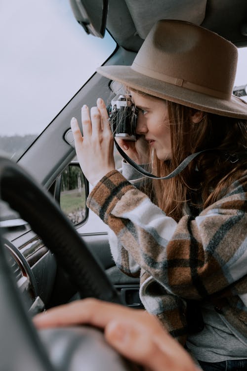 A Woman Using a Camera during a Road Trip