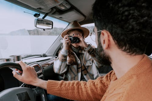 A Woman Using a Camera during a Road Trip