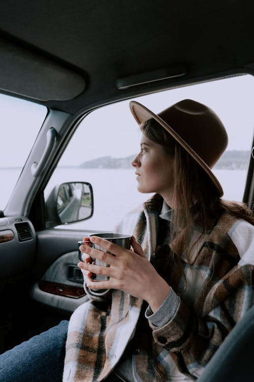 A Woman Having a Drink inside a Car · Free Stock Photo