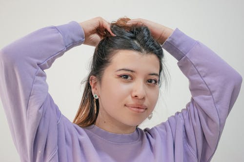 Woman in Purple Long Sleeve Shirt Holding Her Hair