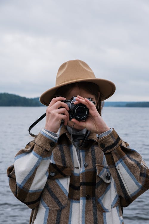 Person Wearing a Brown Hat Taking a Picture