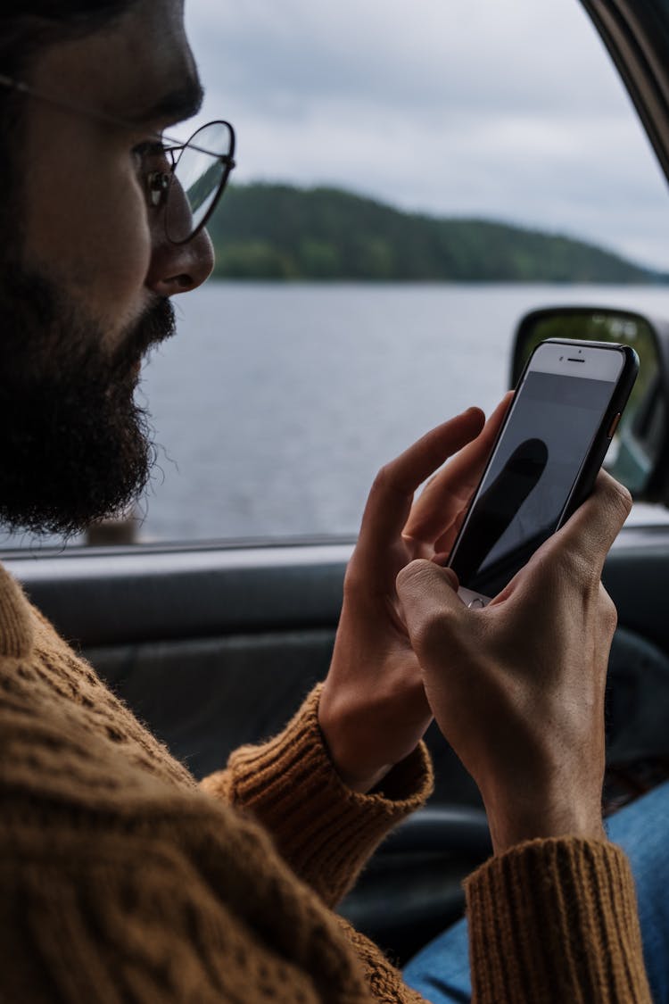 Man Inside The Car Texting On His Phone