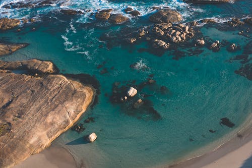 Aerial Photography of Brown Rock Formations on Body of Water