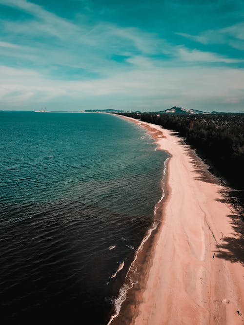 Sandy beach of waving ocean in tropical resort