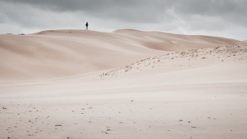 Lonely tourist walking on sandy dunes