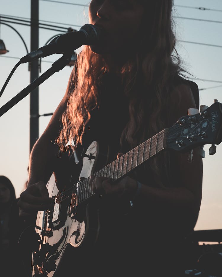 Crop Woman Playing Guitar And Singing