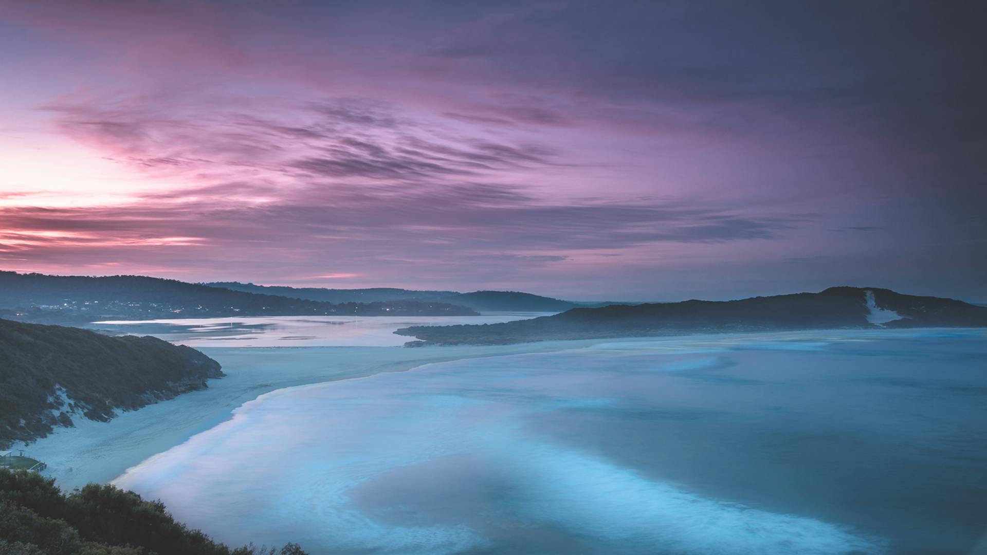 Breathtaking twilight view of tranquil coastal bay with colorful sky and serene waters.