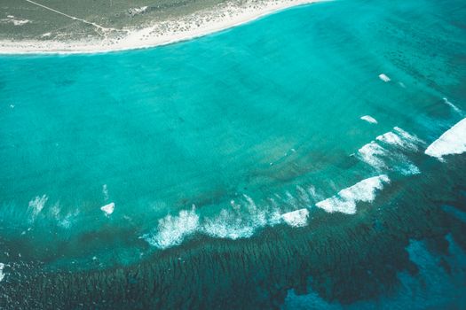 无人机看到碧绿的海水，沙滩附近泛起泡沫和涟漪