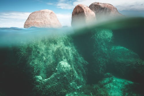 Magnificent view of stony cliffs under transparent water of ocean in sunny summer