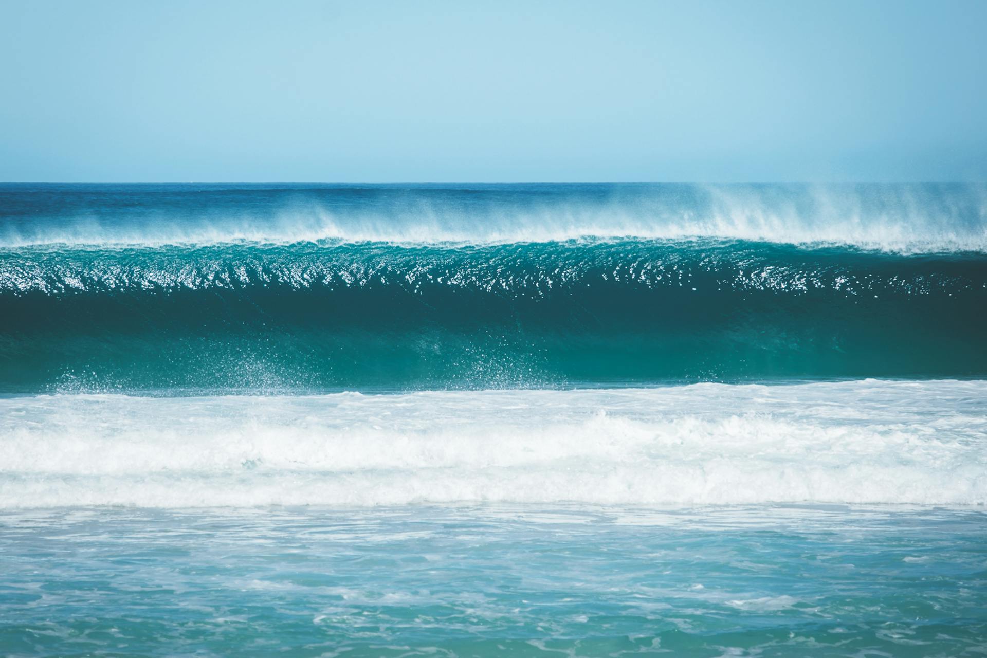 Azure endless sea waves rolling against cloudless blue sky on fair summer weather