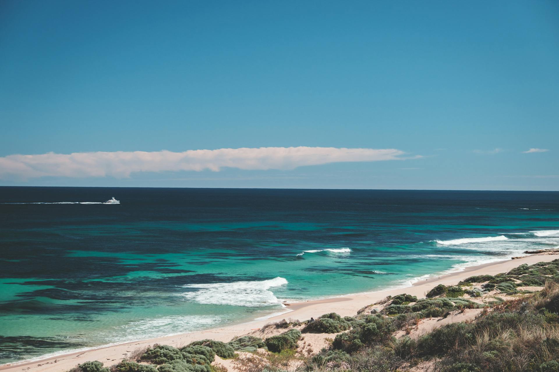 Discover a tranquil beach with azure waters and a clear blue sky. Perfect travel escape.