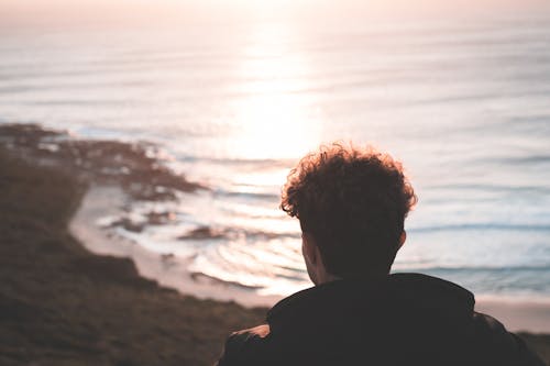 Homme Anonyme Bénéficiant D'un Coucher De Soleil Pittoresque Au Bord De La Mer