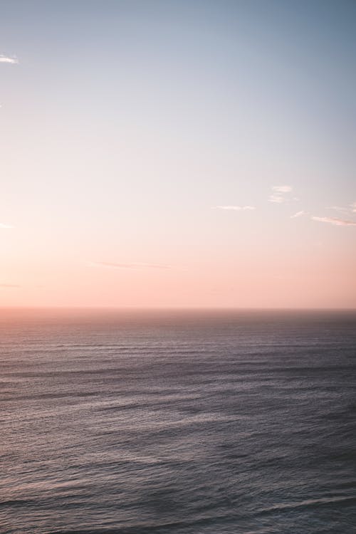 澄んだ青い空の下で青い波打つ海