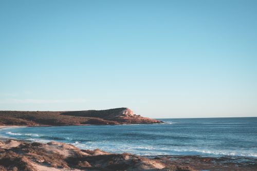 Free Scenery view of rippled ocean with turquoise water washing coastline under blue cloudless sky Stock Photo