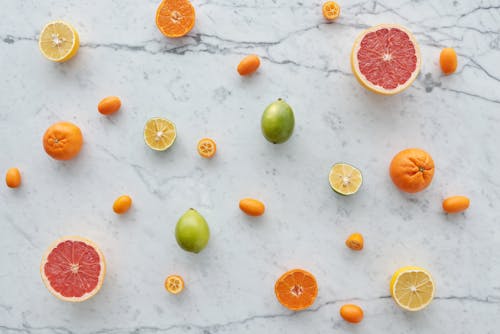Gratis Frutti Verdi Arancioni E Bianchi Sulla Superficie Bianca Foto a disposizione