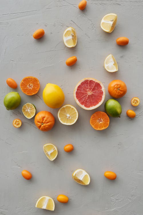 Photo Of Sliced Citrus Fruits On Gray Background