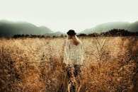 一名妇女在德国奥尔施塔特的麦田中漫步，眺望着周围的群山