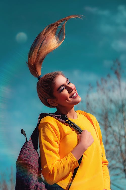 Woman Wearing a Yellow Long Sleeve Flipping Her Hair