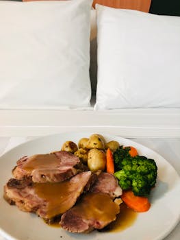 Delicious beef dish with broccoli, potatoes, and carrots served on a plate indoors.