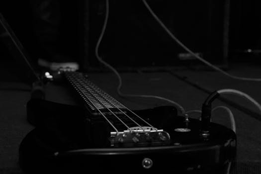 Close-up of a black electric guitar in a dark studio. Perfect for music-related themes.
