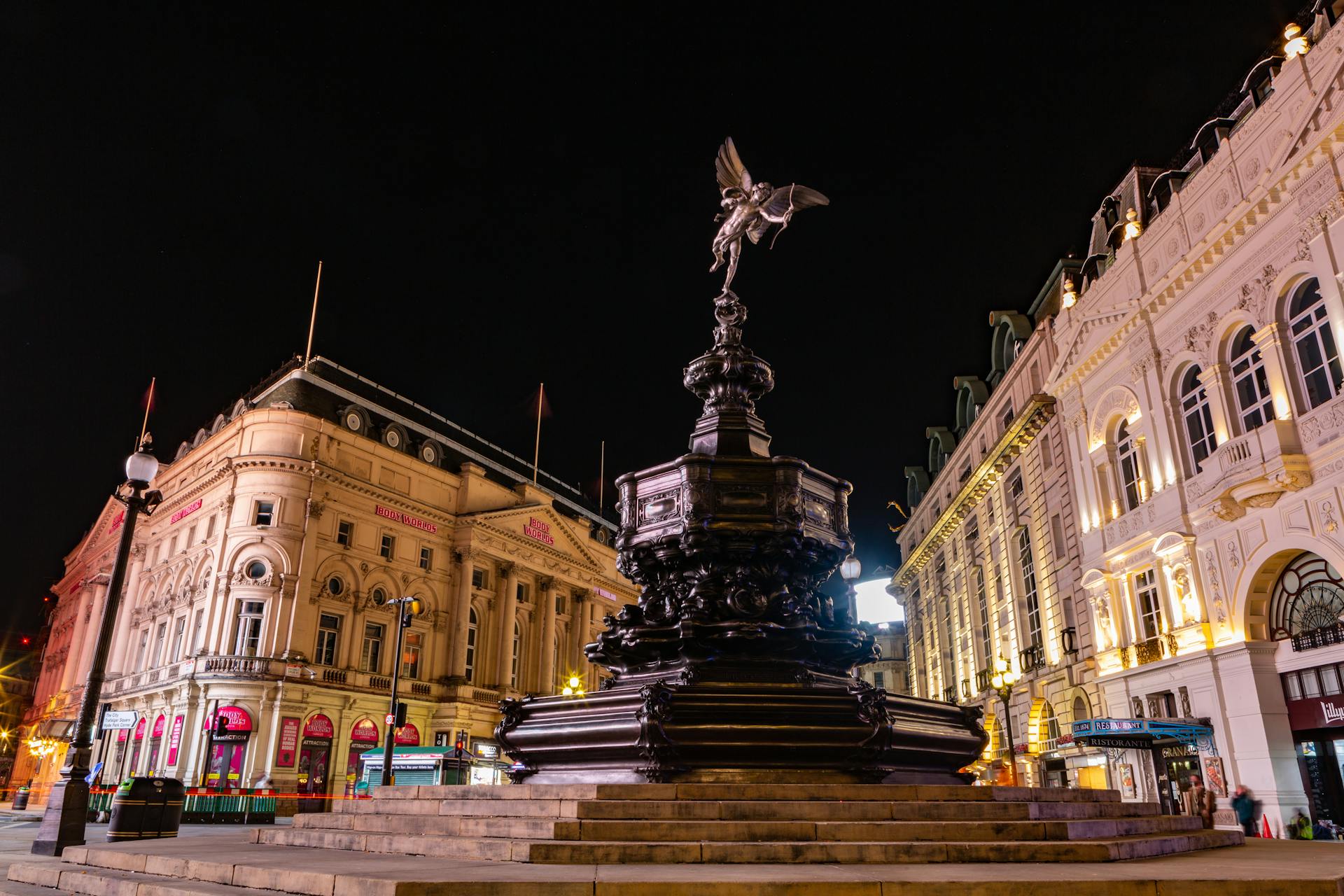 Vibrant nighttime view of the Shaftesbury Memorial Fountain and Eros statue in London's busy Piccadilly Circus.