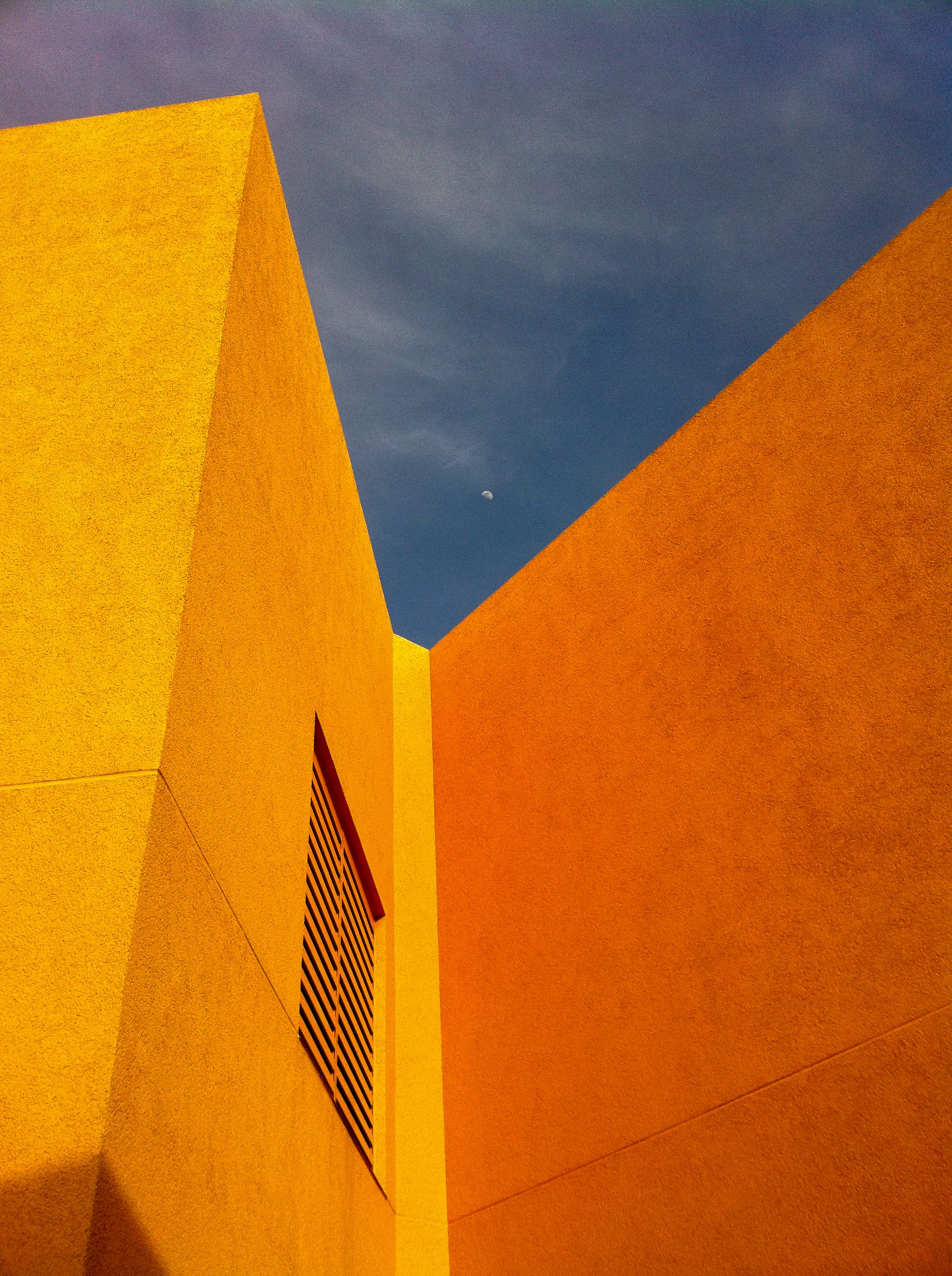 Bright yellow building facade with sharp angles under a clear sky in Emeryville, CA.