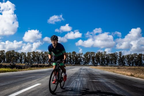 Free Male cyclist riding on a road under blue sky in João Pessoa, PB, Brazil. Stock Photo