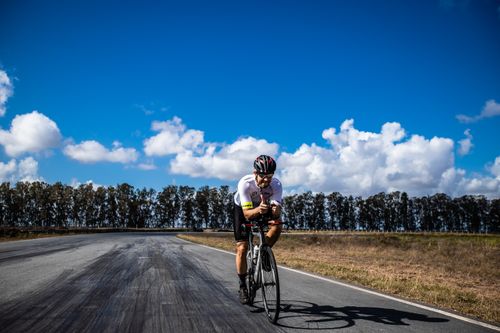 Free A cyclist on a road in João Pessoa, enjoying a sunny day amidst nature and open skies. Stock Photo
