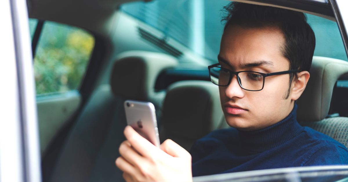 Hispanic man canceling car insurance policy online using smartphone in Florida