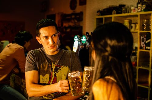 Free Two friends enjoy a relaxed evening at a cozy bar, sharing drinks and conversation. Stock Photo