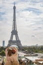 在明亮的天空下，巴黎的游客欣赏着标志性的埃菲尔铁塔，捕捉观光与连接的瞬间