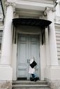 Woman in Black Dress Standing on White Wooden Door