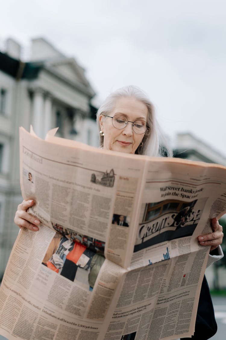 Elderly Woman Reading A Newspaper