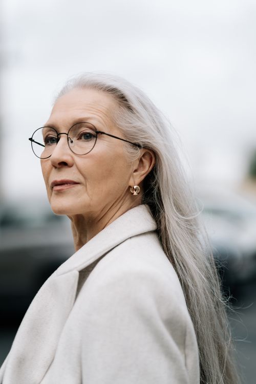 Free Portrait of an elegant senior woman with gray hair and eyeglasses outdoors. Stock Photo