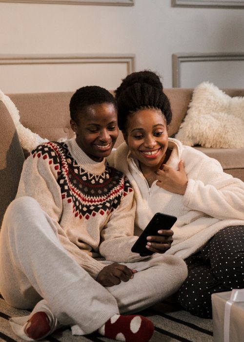 Free Two women enjoy a joyful video call, sharing smiles and warmth in a cozy home setting. Stock Photo