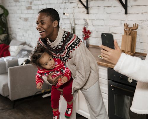 Woman Smiling While Carrying a Child