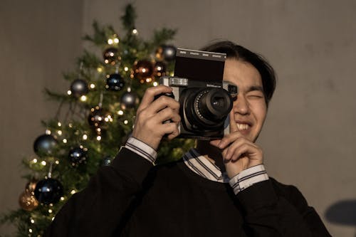 Man Taking Photo with a Polaroid Camera