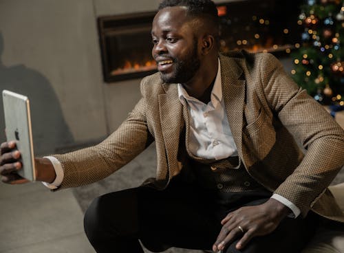 Man in Brown Suit Sitting on A Chair