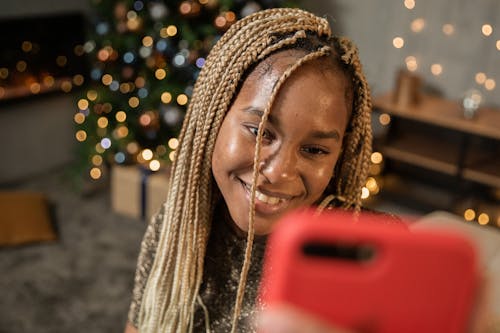 Woman Smiling Holding Red Smartphone