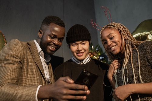 Free Group of friends at a festive gathering sharing joy through a video call. Stock Photo