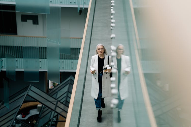 Woman In White Coat Walking On Hallway