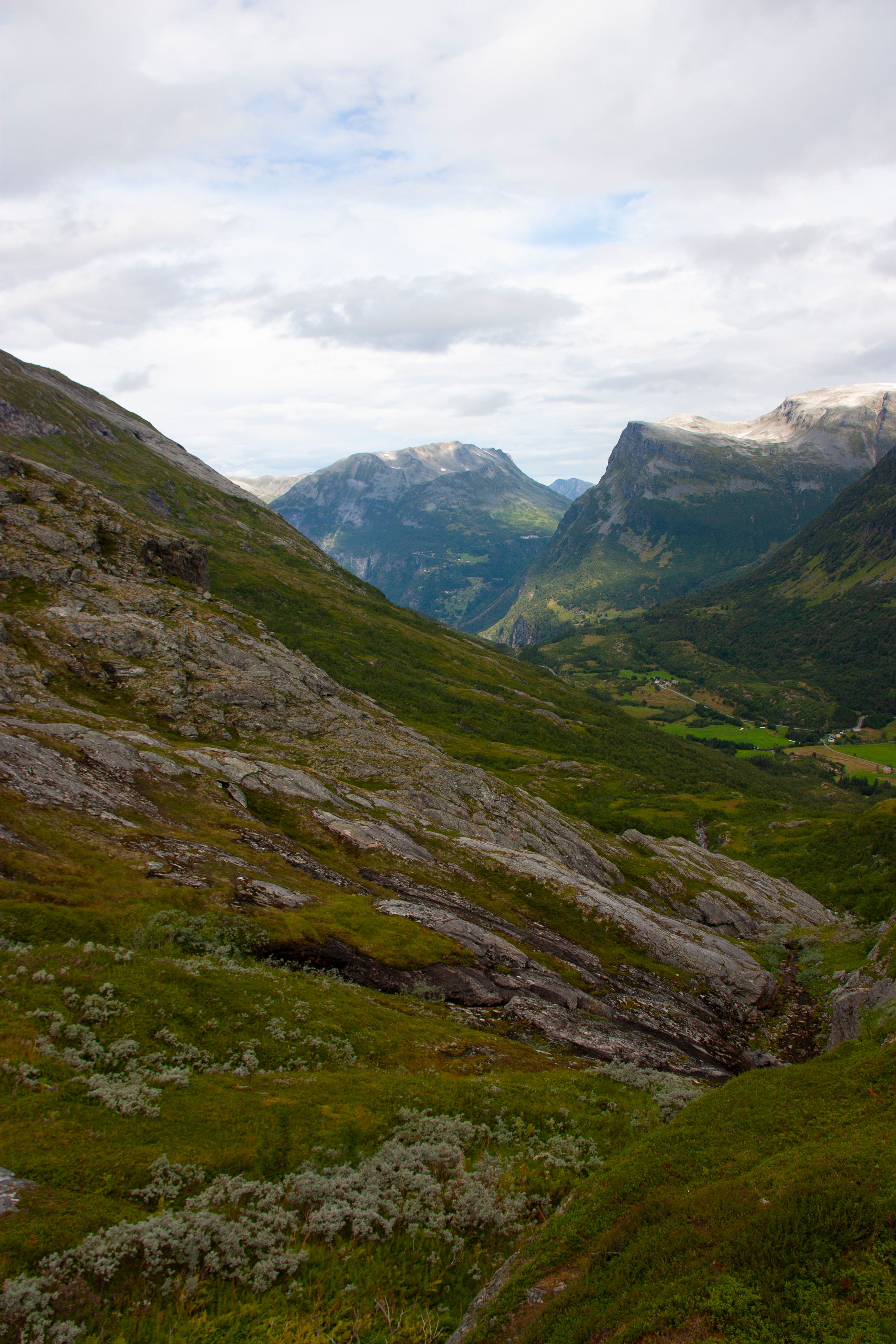 A breathtaking view of lush green mountains and valleys under a cloudy sky.
