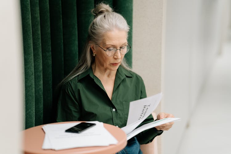 Elderly Woman With Gray Hair Holding Papers