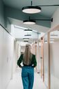 Woman in Green Long Sleeve Shirt and Blue Denim Jeans Standing in Front of Mirror
