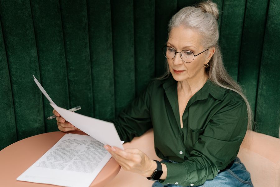 Clara Bennett reading manuscript pages at a table