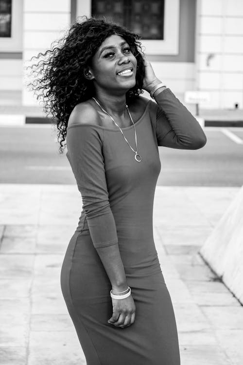 Free Happy black woman with flying hair in trendy dress smiling Stock Photo