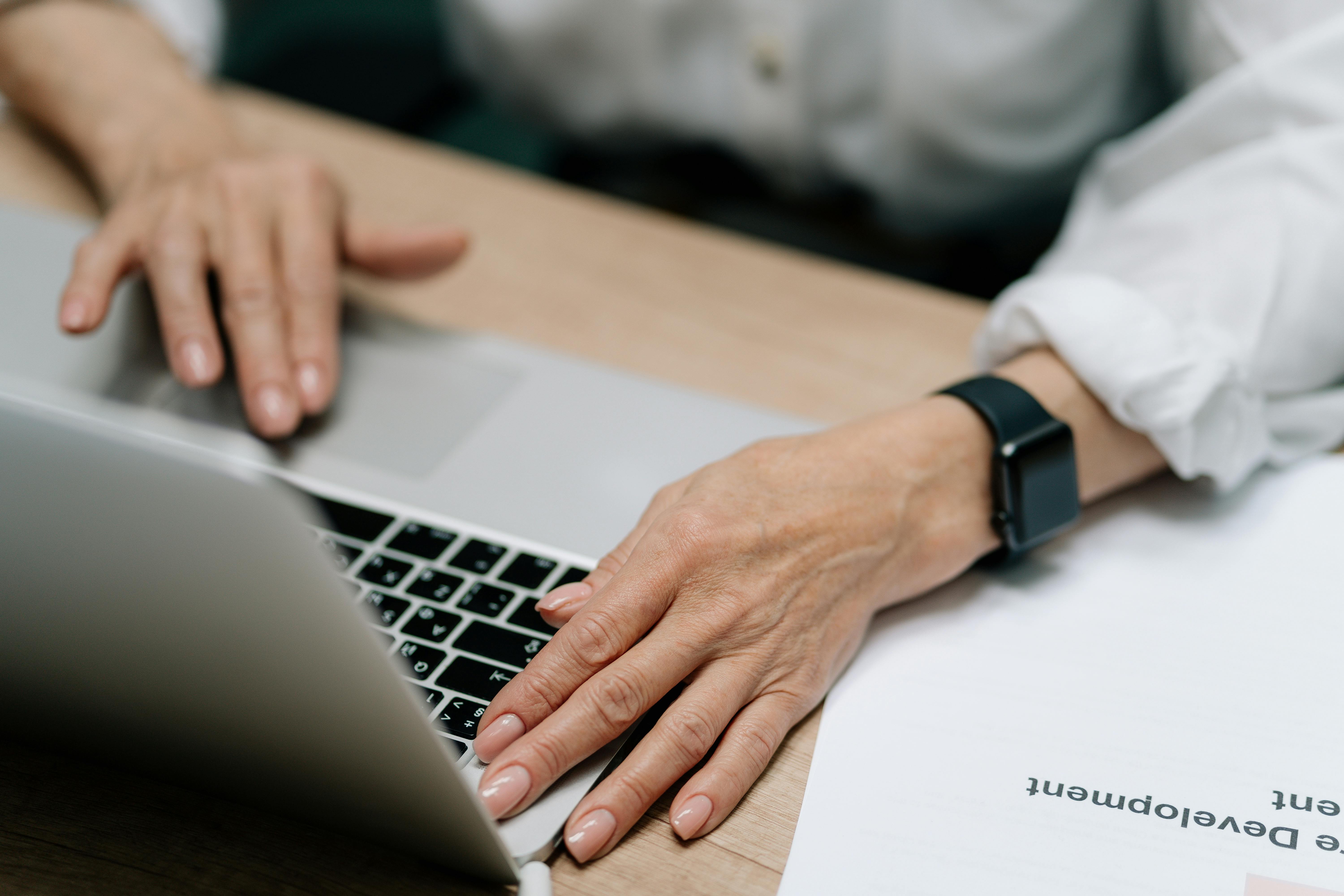 person wearing black watch using laptop